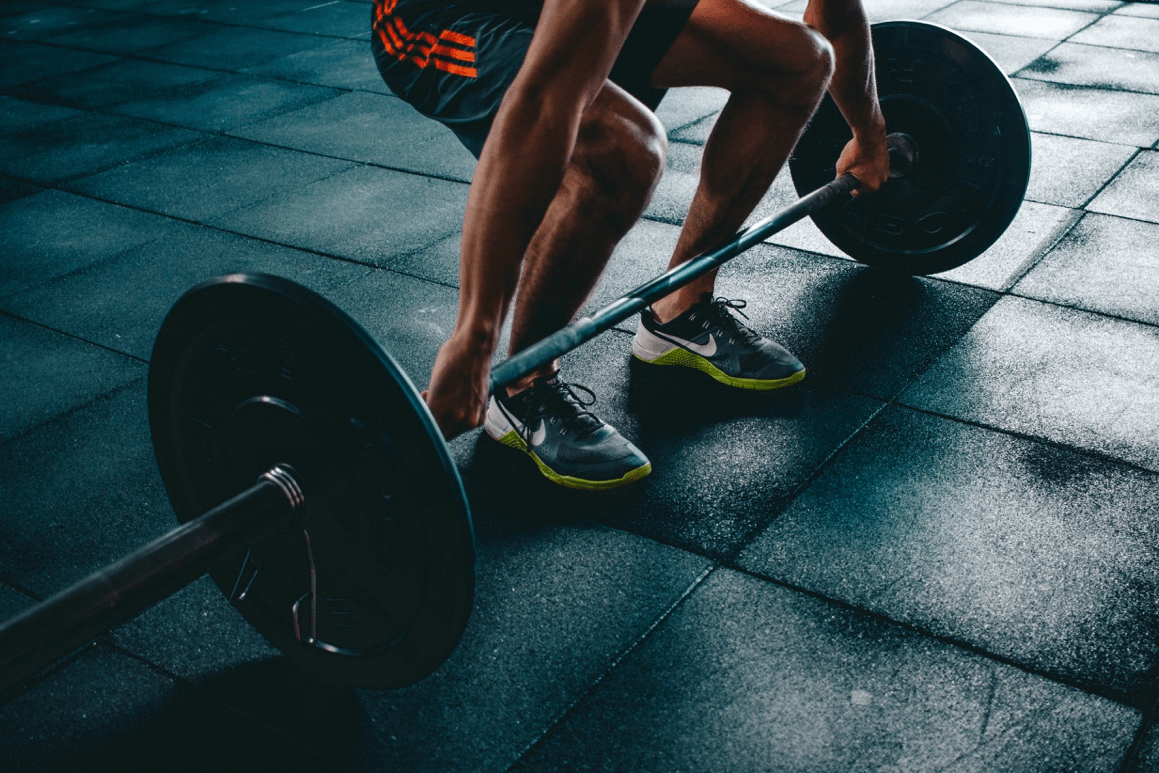 A man is lifting weights at a gym.